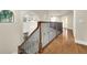 Hallway with hardwood floors and black metal railing overlooks an open foyer at 12222 Cypress Landing Ave, Clermont, FL 34711