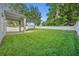 Large grassy backyard enclosed by a white fence, providing ample space for activities at 131 Calabria Springs Cv, Sanford, FL 32771