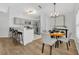 Open-concept dining area with modern lighting, stainless steel appliances, and breakfast bar at 131 Calabria Springs Cv, Sanford, FL 32771