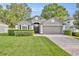 Charming single-Gathering home featuring a paved driveway, lush lawn, and mature trees at 131 Calabria Springs Cv, Sanford, FL 32771