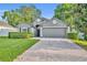 Charming single-Gathering home featuring a paved driveway, lush lawn, and mature trees at 131 Calabria Springs Cv, Sanford, FL 32771