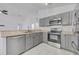 Charming kitchen features gray cabinets, stainless steel appliances and light countertops at 131 Calabria Springs Cv, Sanford, FL 32771