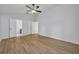 Main bedroom with wood-look floors, multiple doors, and a ceiling fan at 131 Calabria Springs Cv, Sanford, FL 32771