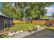 Landscaped backyard featuring a paver patio, green lawn, wooden fence, and a black shed with flower boxes at 14 N Lawsona Blvd, Orlando, FL 32801