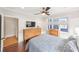 Comfortable bedroom features a large window with blinds, ceiling fan, two dressers, and dark wood floors at 14 N Lawsona Blvd, Orlando, FL 32801