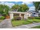 Quaint home exterior showcasing well-maintained lawn, garden, and a side driveway leading to a wooden fence at 14 N Lawsona Blvd, Orlando, FL 32801