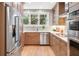 Bright kitchen features stainless steel appliances, wood cabinetry, quartz countertops, and tiled backsplash at 14 N Lawsona Blvd, Orlando, FL 32801