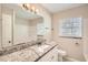 This bathroom has granite countertops and a tub with white tile at 1602 Sheffield Rd, Leesburg, FL 34748