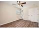 A cozy bedroom features a ceiling fan, closet, window and modern wood-look flooring at 1602 Sheffield Rd, Leesburg, FL 34748