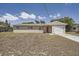 Charming single-story home with a red front door and attached one car garage at 1602 Sheffield Rd, Leesburg, FL 34748