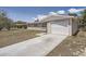 Exterior view of the home's attached one car garage and concrete driveway at 1602 Sheffield Rd, Leesburg, FL 34748