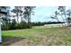 The property features a large, grassy backyard with scattered trees and power lines at 16908 Sw 44Th Cir, Ocala, FL 34473