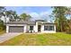 Charming single-story home with a gray driveway, inviting yellow front door, and well-maintained landscaping at 16908 Sw 44Th Cir, Ocala, FL 34473
