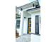 Close-up of a modern home's yellow front door framed by white columns and black accents at 16908 Sw 44Th Cir, Ocala, FL 34473