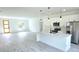 Bright, open kitchen featuring white cabinets, an island, stainless steel appliances, and an adjacent living area at 16908 Sw 44Th Cir, Ocala, FL 34473