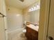 A bathroom featuring a neutral vanity, mirror, and tiled shower/tub combo at 1695 Lee Rd # E214, Winter Park, FL 32789
