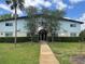 Charming two-story condo building with well-maintained landscaping, a walkway, and trees at 1695 Lee Rd # E214, Winter Park, FL 32789