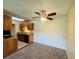 Cozy carpeted dining area adjacent to an efficient kitchen with wood cabinets and modern appliances at 1695 Lee Rd # E214, Winter Park, FL 32789