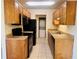 The kitchen features wood cabinets, black appliances and light colored tile floors at 1695 Lee Rd # E214, Winter Park, FL 32789