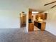View of the kitchen from the carpeted living room, which is well lit at 1695 Lee Rd # E214, Winter Park, FL 32789