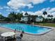 Community pool features bright blue water, lounge chairs, and a clear blue sky at 1695 Lee Rd # E214, Winter Park, FL 32789