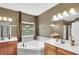 Bright bathroom boasts a garden tub, large window, dual vanities, and updated fixtures at 17117 Cypress Preserve Pkwy, Orlando, FL 32820