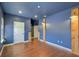 Bedroom with unique wooden posts, hardwood floors, blue walls, and windows on each side at 17117 Cypress Preserve Pkwy, Orlando, FL 32820