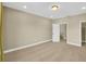 Large carpeted bedroom with neutral walls, featuring a door and closet entrance at 17117 Cypress Preserve Pkwy, Orlando, FL 32820