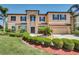 Inviting two-story home with a manicured lawn, mature landscaping, and a welcoming entrance at 17117 Cypress Preserve Pkwy, Orlando, FL 32820