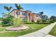 Beautifully landscaped home with palm trees, lush lawn, and a charming stone accent wall at 17117 Cypress Preserve Pkwy, Orlando, FL 32820