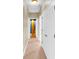 Hallway with beige walls, carpet floors, white doors and a peek into a blue room at 17117 Cypress Preserve Pkwy, Orlando, FL 32820