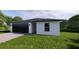 New construction home featuring a minimalist style, lush lawn, and an attached garage at 17445 Sw 25Th Ct, Ocala, FL 34473