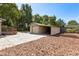 Exterior of a backyard, showing a garage and a patio surrounded by trees at 210 E Kaley St, Orlando, FL 32806