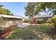 A green backyard with a home and a garage, with a patio and deck in the background at 210 E Kaley St, Orlando, FL 32806