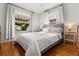 Comfortable bedroom featuring hardwood floors, a plush bed with white linens, and natural light from large windows at 210 E Kaley St, Orlando, FL 32806