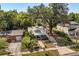 Quaint home with a welcoming porch and well-manicured lawn, set beneath a mature oak at 210 E Kaley St, Orlando, FL 32806