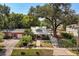 Inviting home featuring a charming porch, verdant yard and mature trees at 210 E Kaley St, Orlando, FL 32806