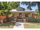 Charming home featuring a red door, covered porch, and well-manicured landscaping at 210 E Kaley St, Orlando, FL 32806