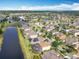 An aerial view of a community with pond views and homes with solar panels and screened pools at 2145 Plantation Oak Dr, Orlando, FL 32824