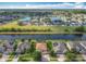 Aerial view of a residential area showcasing beautiful homes, green spaces, and a tranquil lake at 2145 Plantation Oak Dr, Orlando, FL 32824