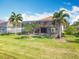 Expansive backyard offers a screened-in patio, lush grass, and mature landscaping at 2145 Plantation Oak Dr, Orlando, FL 32824