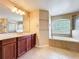 Bright bathroom features double sinks, a soaking tub, and a separate glass-enclosed shower for a spa-like experience at 2145 Plantation Oak Dr, Orlando, FL 32824