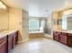 Bright bathroom with double vanities, a soaking tub, and a glass-enclosed shower offering luxury at 2145 Plantation Oak Dr, Orlando, FL 32824