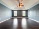 Expansive bedroom with dark floors, two windows, a trey ceiling, and a ceiling fan at 2145 Plantation Oak Dr, Orlando, FL 32824