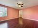 A serene bedroom with hardwood floors, ceiling fan, and large window at 2145 Plantation Oak Dr, Orlando, FL 32824