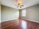 This bedroom offers hardwood floors, a ceiling fan, and a bright window at 2145 Plantation Oak Dr, Orlando, FL 32824