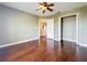 Bedroom showcasing hardwood floors, ceiling fan, and an open closet at 2145 Plantation Oak Dr, Orlando, FL 32824