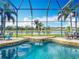 Stunning screened pool with spa and peaceful canal views, surrounded by lush landscaping and patio seating at 2145 Plantation Oak Dr, Orlando, FL 32824