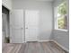 Bright bedroom with two white doors, grey walls, wood-look floors, and a window letting in lots of natural light at 2259 3Rd Ave, Deland, FL 32724