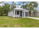 Cozy single-Gathering home featuring a well-manicured lawn, gray front door, and garage at 2259 3Rd Ave, Deland, FL 32724